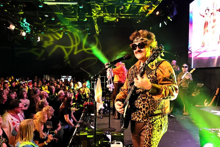 Bühne & Saal: Porno al Forno live, BOBAUS TEXAS, Guitar Weitwinkel: Bühne mit Performer und dichtem Publikum, Lichtshow im Saal.