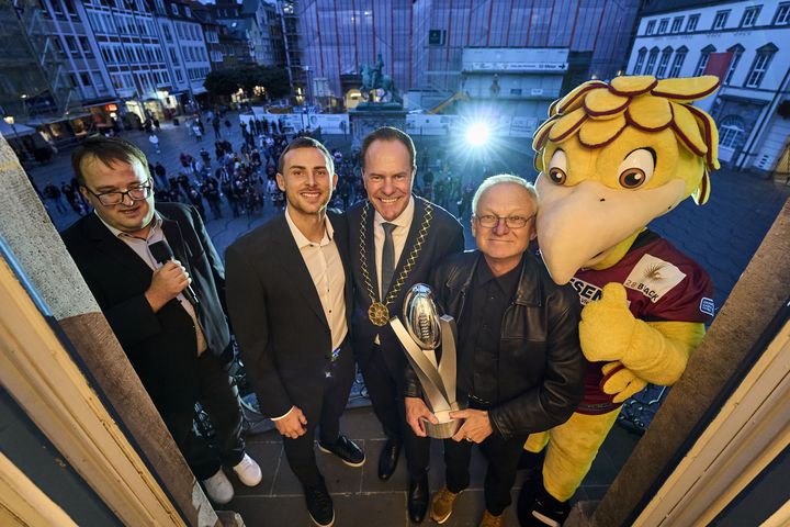 Der ELF-Pokal wurde auf dem Rathausbalkon den Fans auf dem Marktplatz präsentiert, mit dabei (v.r.): Defensive Coordinator Richard Kent, OB Dr. Stephan Keller und Quarterback Jadrian Clark © Landeshauptstadt Düsseldorf/Claus Langer 