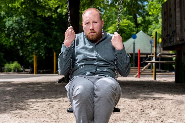 Julius Fischer – „Ich hasse Menschen. Eine Fortpflanzung" Julius Fischer sitzt auf einer Schaukel auf einem Spielplatz und blickt ernst in die Kamera