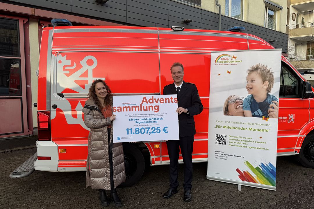 Feuerwehrchef David von der Lieth (r.) übergibt den symbolischen Spendenscheck an Mascha Kloster vom Regenbogenland / Foto: Landeshauptstadt Düsseldorf 