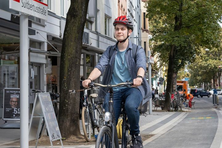 Radkap an der Suitbertusstraße Ein Radfahrer fährt über den angehobenen Radweg an der Haltestelle Suitbertusstraße in Düsseldorf-Bilk