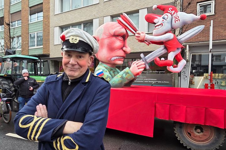 Jacques Tilly vor dem Mottowagen „Putin vs. Narr (Satire)“ (Rosenmontag 2026) Jacques Tilly steht beim Rosenmontagszug 2026 in Düsseldorf vor dem Mottowagen „Putin vs. Narr (Satire)“