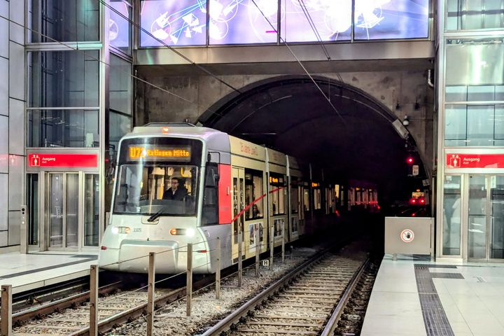 Rheinbahn U‑Bahn in Düsseldorf während des laufenden Betriebs Einfahrende Rheinbahn‑Stadtbahn an einer Düsseldorfer U‑Bahn‑Station mit Tunnel, Gleisen und Bahnsteig.